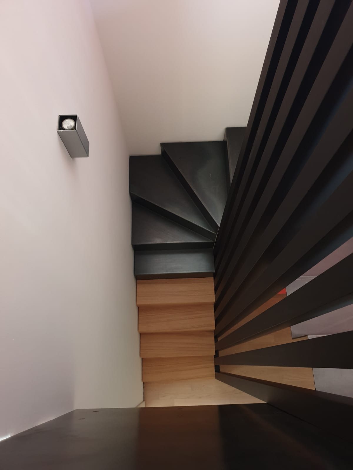 Scala a sbalzo in acciaio verniciato nero con balaustra a listelli verticali